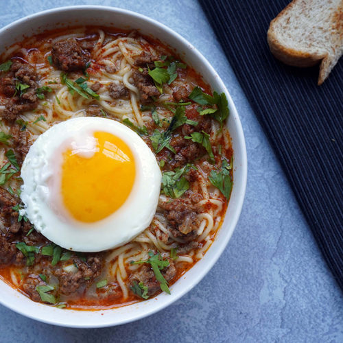 sopa criolla peruana con huevo frito y pan en un tazón - Peruvian sopa criolla with fried egg and bread in a bowl