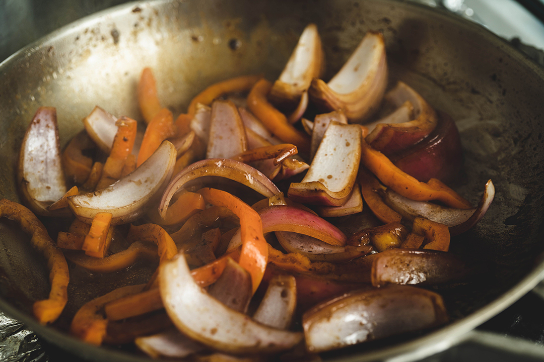 Cebollas rojas y ají amarillo salteados a fuego alto para Lomo Saltado