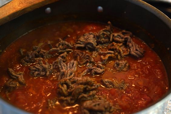 Carne molida dorada mezclada con salsa de tomate y ají panca para Tallarines Rojos