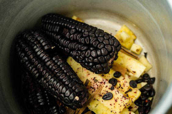 a pic of purple corns, and pineapples on a pot