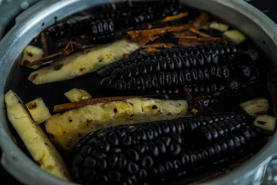a pic purple corn, pineapple and spices on a pot