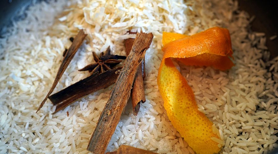 Arroz con leche white rice cooking in a pot with cinnamon sticks cloves and orange peel - Arroz con leche arroz blanco cocinándose en una olla con ramas de canela clavos y cáscara de naranja