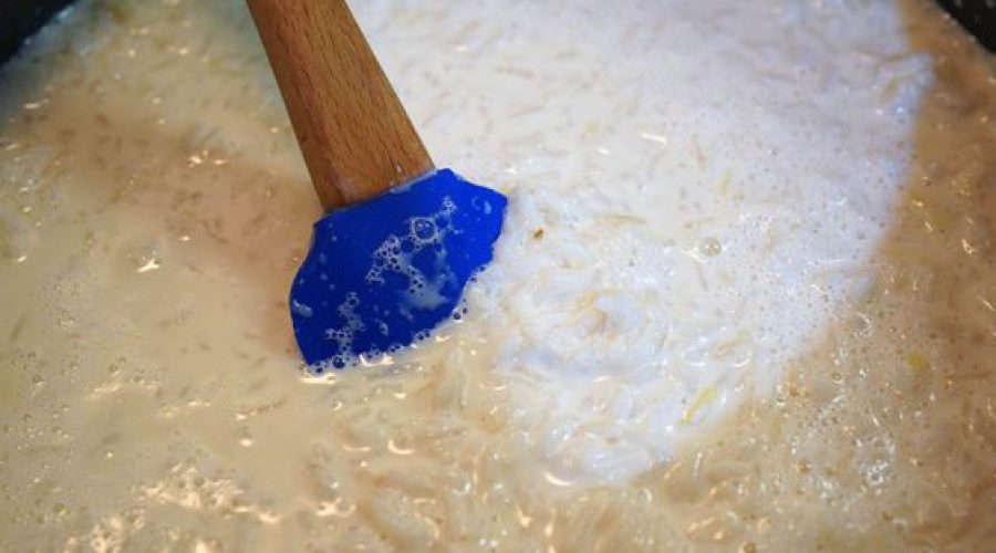 Arroz con leche thick creamy rice pudding simmering in a pan with condensed milk - Arroz con leche pudín de arroz espeso y cremoso cocinándose a fuego lento en una olla con leche condensadaArroz con leche thick creamy rice pudding simmering in a pan with condensed milk - Arroz con leche pudín de arroz espeso y cremoso cocinándose a fuego lento en una olla con leche condensada