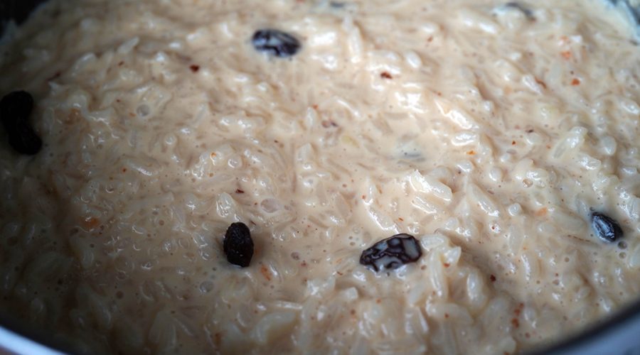 Arroz con leche thick creamy rice pudding simmering in a pan with condensed milk - Arroz con leche pudín de arroz espeso y cremoso cocinándose a fuego lento en una olla con leche condensada