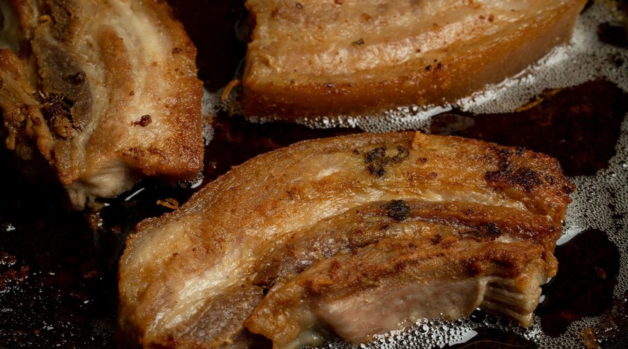 panceta de cerdo cocinándose en su propia grasa hasta quedar crujiente - pork belly cooking in its own fat until crispy