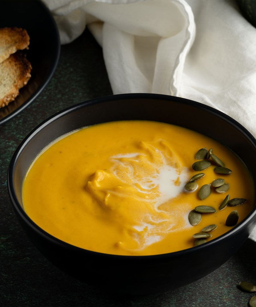 crema de zapallo peruana en tazón con pepitas y pan tostado - Peruvian crema de zapallo in a bowl with pepitas and toasted bread