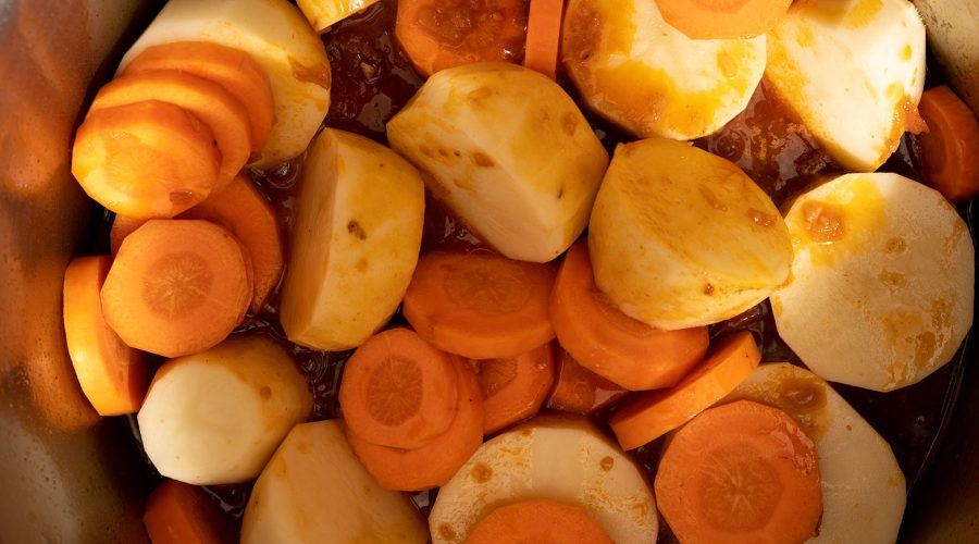 papas y zanahorias cocinándose en estofado de pollo peruano - potatoes and carrots cooking in peruvian chicken stew