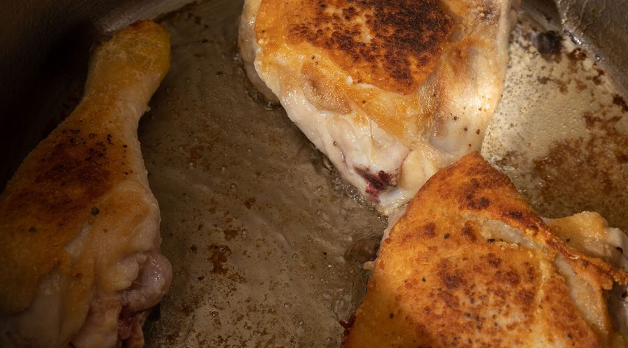 "pollo sellándose en olla caliente para estofado de pollo peruano - chicken browning in hot pot for peruvian chicken stew
