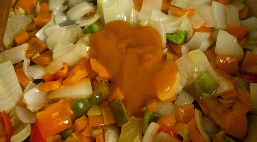 a pic of onions, peppers being cooked on a pan