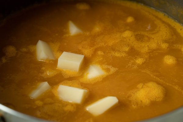 Locro de Zapallo cooking - Peruvian pumpkin stew simmering with squash aji amarillo and broth
