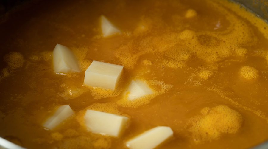 Locro de Zapallo cooking - Peruvian pumpkin stew simmering with squash aji amarillo and broth