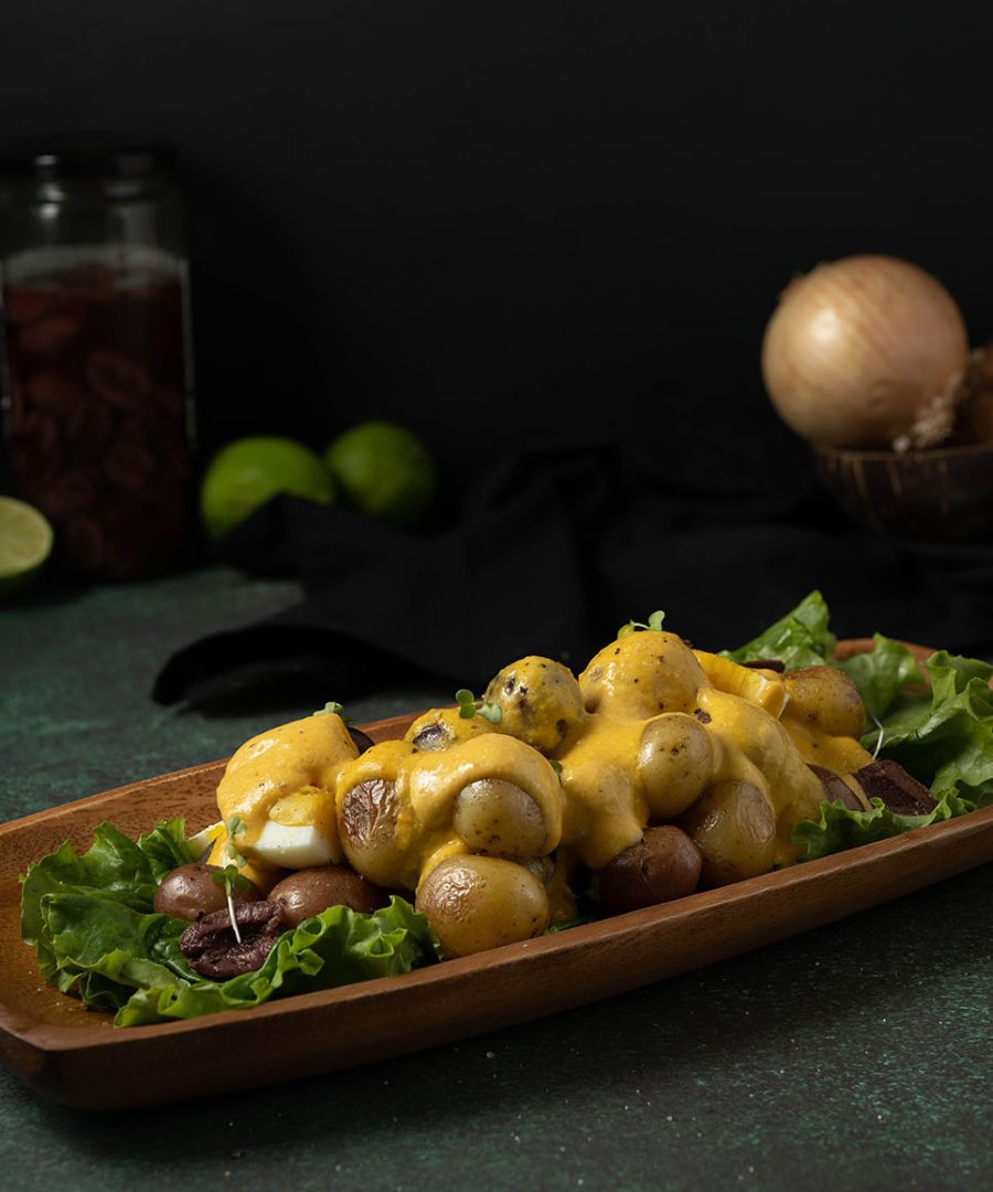 Papa a la huancaina peruvian cheese sauce poured over boiled potatoes with hard boiled egg - Papa a la huancaina salsa de queso peruana servida sobre papas cocidas con huevo duro