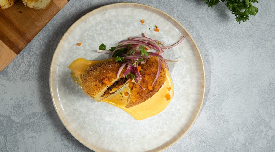 papa rellena peruana crujiente con sarza criolla - crispy peruvian papa rellena stuffed potatoes with pickled onion salad