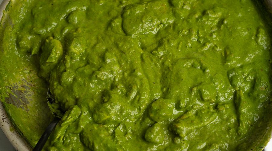 Seco de mariscos thick green cilantro sauce simmering in a pot with carrots and peas - Seco de mariscos salsa verde espesa de cilantro cocinándose a fuego lento en una olla con zanahorias y guisantes