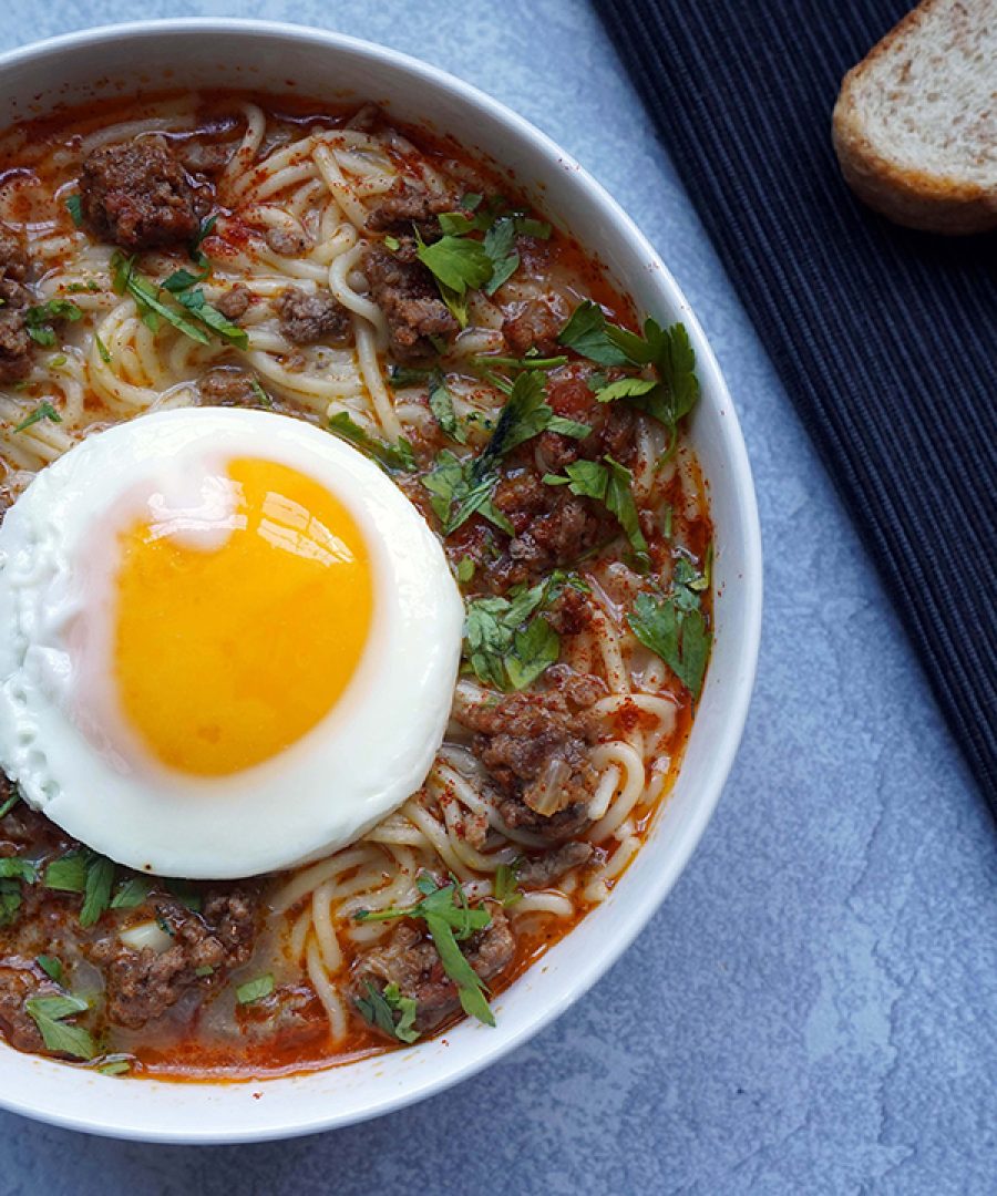 sopa criolla peruana con huevo frito y pan en un tazón - Peruvian sopa criolla with fried egg and bread in a bowl