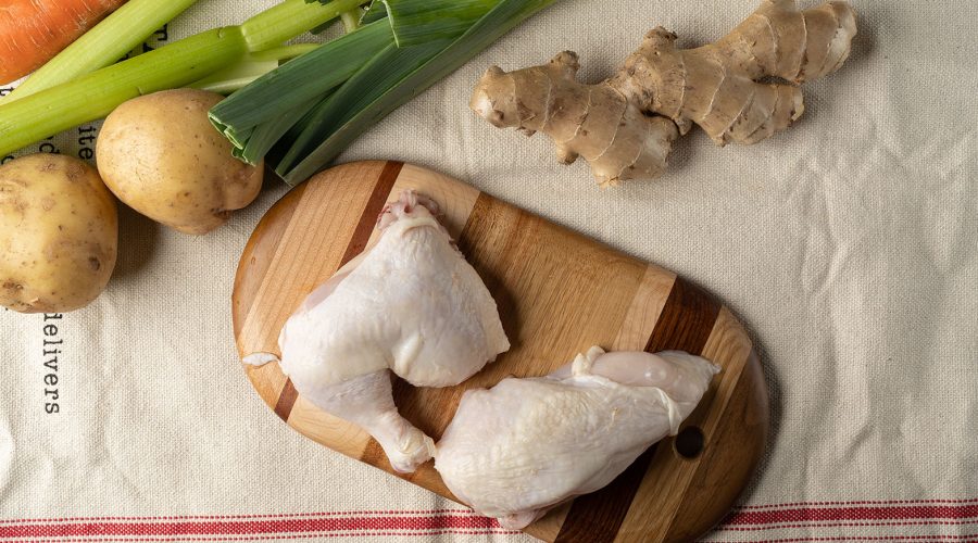 ingredientes crudos sobre tabla: gallina, papas, zanahorias, cebollín, jengibre: Ingredientes para caldo de gallina peruano sobre tabla de madera - raw ingredients for peruvian caldo de gallina on wooden board