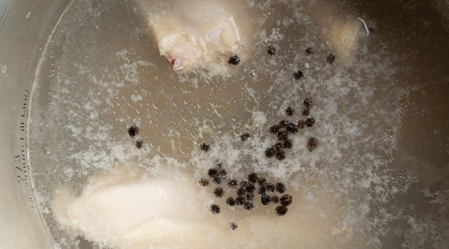 Gallina hirviendo en olla grande con granos de pimienta - hen boiling in large pot with whole peppercorns